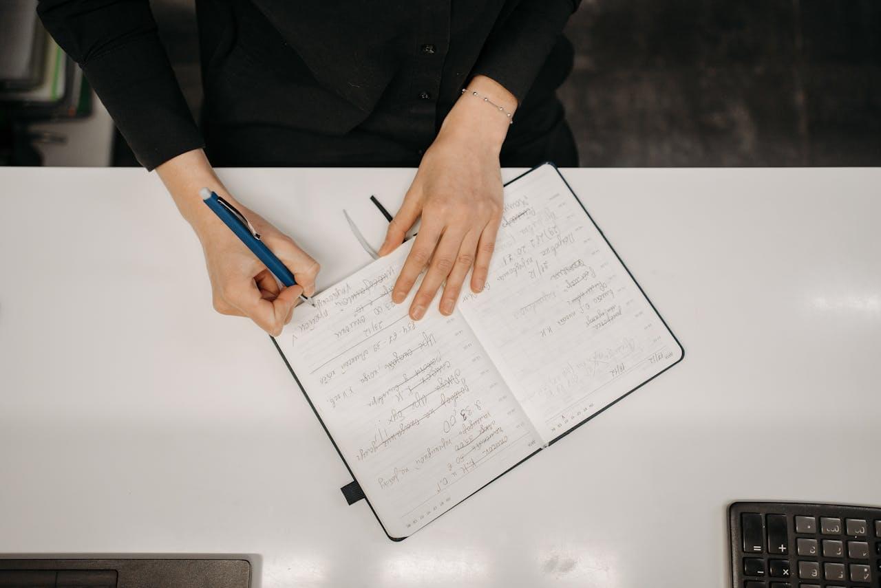 Человек планирует задачи в блокноте